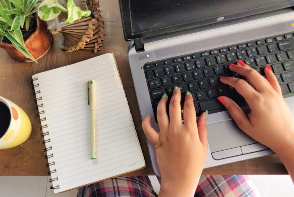 woman using her laptop to write her resume