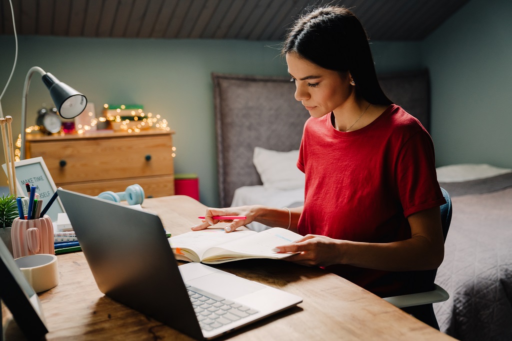 A woman writing work history on entry level IT resume