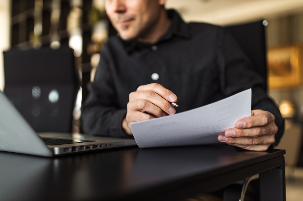 aspiring IT professional carefully reviewing his IT cover letter