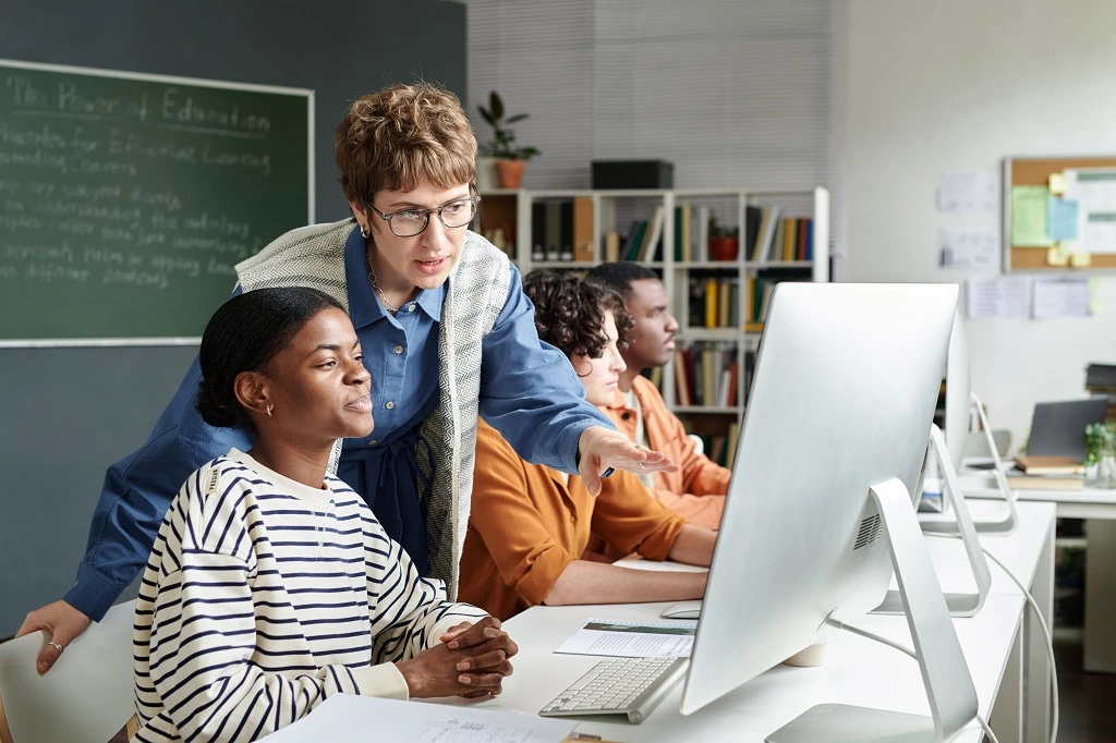 instructor guiding students on computers, illustrating how to list education on a resume effectively