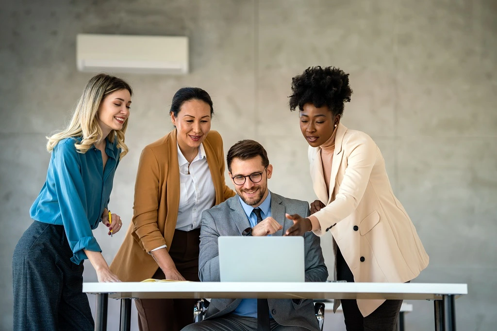 it professionals discussing around laptop during an interview, highlighting resume accomplishments examples.