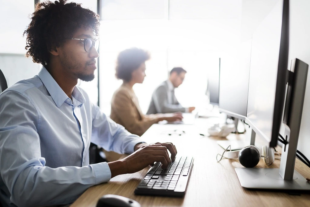 software developers at desks, representing workplace goals examples.